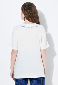 Bílá tričko s krátkými rukávy, na zadní straně s modrým nápisem "potápěj se s proudem" a grafikou ryb. Hladký materiál, uvolněný střih.