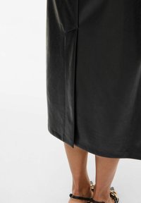 Zwarte leren midi-jurk met een zijschort, gladde textuur en een eenvoudig ontwerp. De zoom is recht en eindigt net boven de enkel.