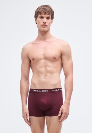 Burgundy boxer briefs with a black elastic waistband featuring white text. Smooth fabric, fitted design, and mid-thigh length.