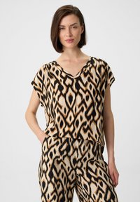 Top mit Leopardenmuster und passender Hose in Beige, Schwarz und Orange; aus leichtem Stoff mit lockerer Passform und V-Ausschnitt gefertigt.