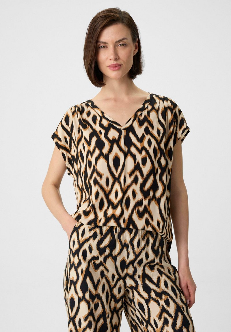 Top mit Leopardenmuster und passender Hose in Beige, Schwarz und Orange; aus leichtem Stoff mit lockerer Passform und V-Ausschnitt gefertigt.