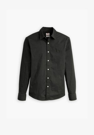 Chemise noire à manches longues avec boutons, en coton, présentant un col pointu, des boutons blancs et un petit logo sur la poche poitrine gauche.