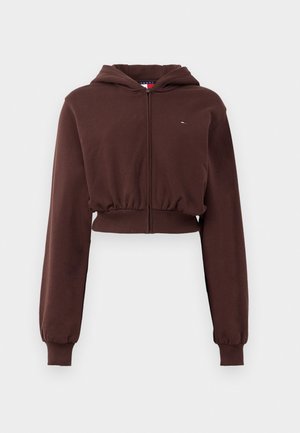 Bruine cropped zip-up hoodie gemaakt van zachte stof, met lange mouwen, geribde boorden en een klein logo op de borst.