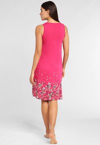 Pink sleeveless dress with floral pattern at the hem, made from soft fabric, featuring a flared shape and knee-length cut.