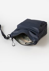 Borsa a spalla in nylon blu con zip aperta, che mostra una tasca interna e una superficie liscia. Cinghia regolabile con elementi in metallo.