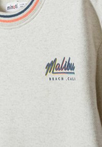 Világosszürke pulóver bordás nyakkal, piros, tengerészkék és narancssárga díszítéssel. Az "Malibu Beach Cali" felirat színes hímzéssel készült.