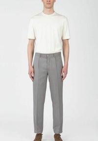 Ljusgrå skräddarsydda byxor med en subtil randig design, strukturerad passform och framknäppning; kombineras med en enfärgad vit t-shirt.