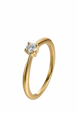 Anillo solitario de oro con un solo diamante redondo sujeto por cuatro garras sobre una banda lisa y pulida sobre un fondo blanco.