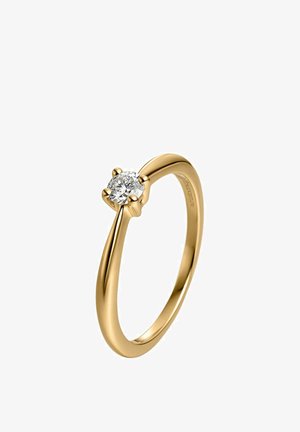 Anillo solitario de oro con un solo diamante redondo sujeto por cuatro garras sobre una banda lisa y pulida sobre un fondo blanco.