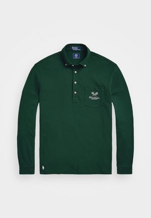 Roheline pika varrukaga polo särk, mis on valmistatud puuvillast, varustatud kraega, viie nupuga, vasakpoolse rinna taskuga, millel on tennise reketi tikand, ning logoga ääres.