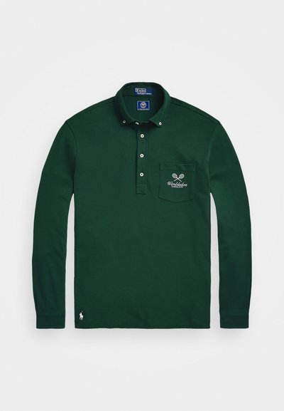 Zelena dolgimi rokavi polo majica iz bombaža, ki ima ovratnik, pet gumbov, žep na levi strani prsnega dela z vezenjem teniškega reketa in logo na robu.