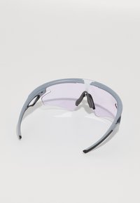 Sonnenbrille mit grauem Kunststoffrahmen und lila getönten Gläsern, mit geschwungenem Design und gummierten Akzenten an den Nasenpads.