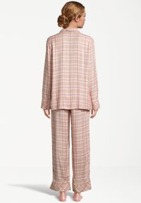 Langarm, geruit pyjama set in tinten van roze en beige. Bevat een knoopsluiting shirt en losse broek met een licht uitlopende zoom.
