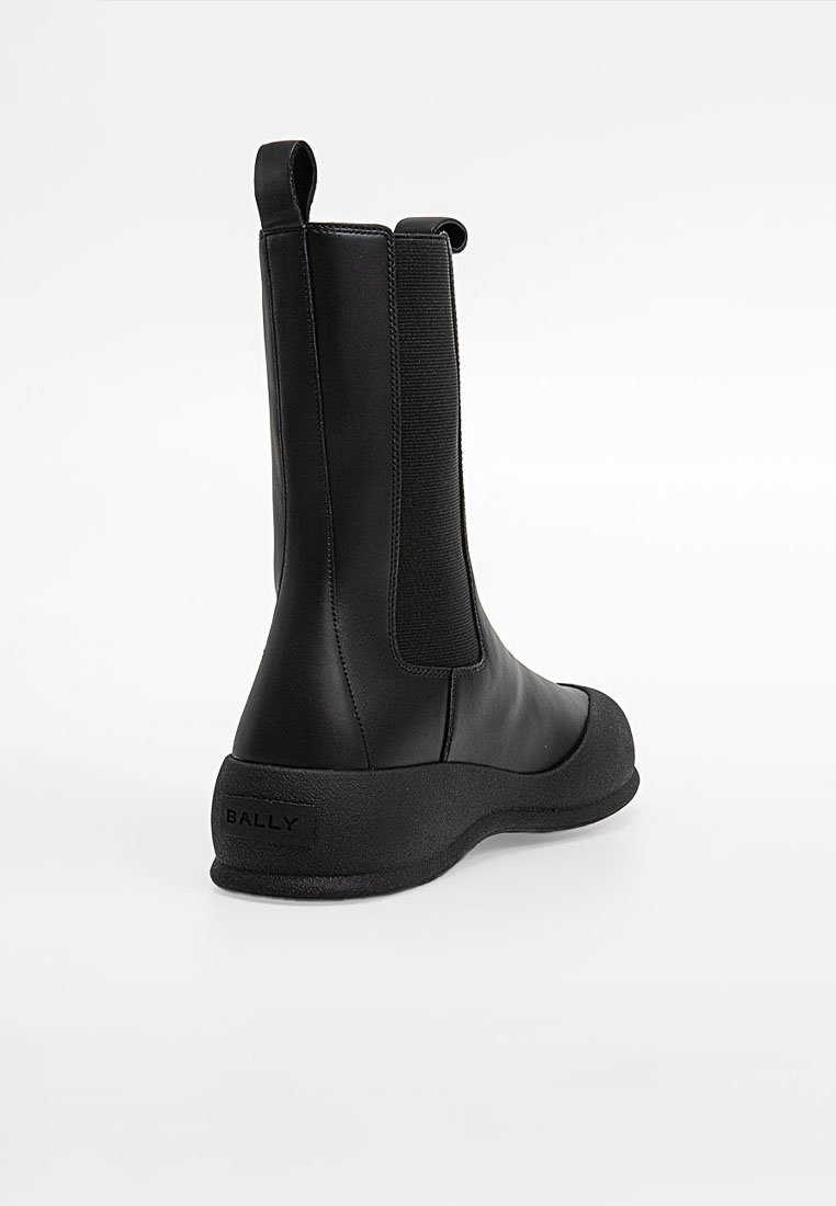 Czarne skórzane botki za kostkę z elastycznymi bokami, zaokrąglonym noskiem i teksturowaną gumową podeszwą. Posiadają pętelkę na pięcie i wytłoczone logo.