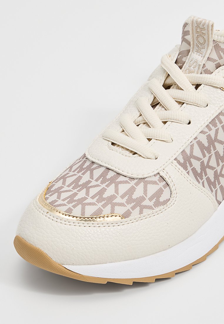 Beige Sneakers mit einem strukturierten Lederoberteil, das ein geometrisches Muster in Hellbraun aufweist. Goldene Akzentdetails und eine weiße Sohle.
