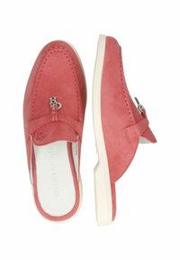 Rosa mockaskinn slip-on skor med rund tå, kontrasterande vit gummisula och en metallisk logotypdetalj på framremmen.