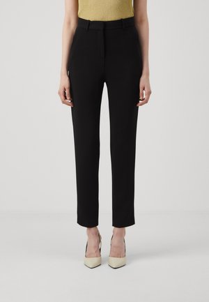 Pantaloni neri su misura con vita alta, gamba dritta e tessuto liscio. Presentano tasche frontali e un sottile dettaglio annodato.