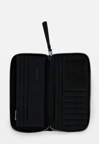 Portafoglio in pelle nera con chiusura a zip, numerosi scomparti per carte, una tasca trasparente per l'ID e un interno testurizzato. Presenta un attacco per cinturino da polso.