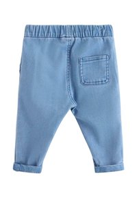 Hellblaue Jeans mit elastischem Bund, umgeschlagenen Säumen und einer einzelnen Gesäßtasche. Hergestellt aus einem weichen, glatten Stoff.