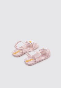 Chanclas de goma rosa con un patrón floral y un acento de margarita blanca, que cuentan con una correa y una suela texturizada para mayor agarre.