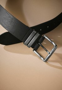 Ceinture en cuir noir avec une texture lisse, dotée d'une boucle en métal argenté à design à double barre horizontale et de plusieurs trous d'ajustement.