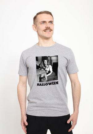 Grå bomulds t-shirt med et sort-hvidt grafisk print af en karakter fra Halloween, med fed tekst nedenfor i sort.