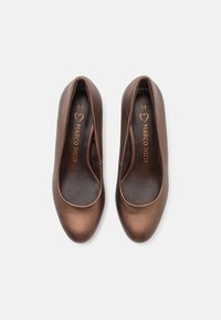 Ballerines en cuir marron avec un bout arrondi et une texture lisse. Présentent un design à découpes basses et un branding subtil à l'intérieur. Taille 37.