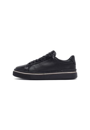 Black leather sneakers with a sleek design, round toe, lace-up front, and a thick rubber sole featuring a metallic accent around the base.