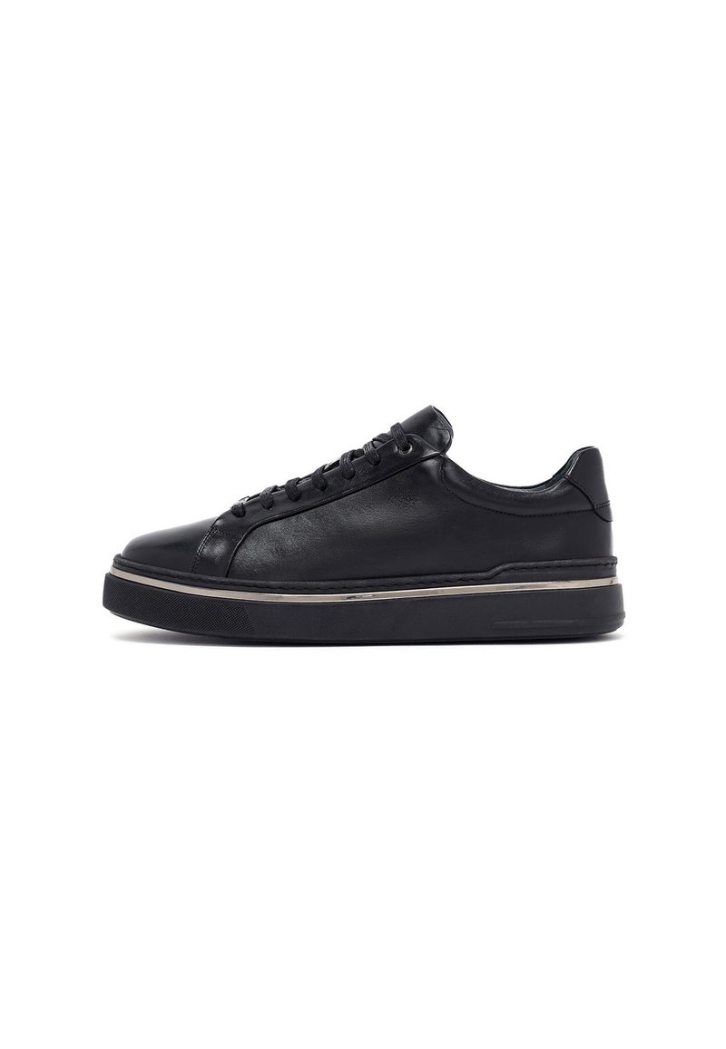 Sneaker in pelle nera dal design elegante, punta rotonda, con lacci davanti e una suola in gomma spessa decorata con un accento metallico alla base.
