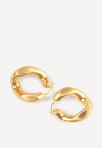Un paio di lucenti orecchini a cerchio in oro spesso, con forme irregolari e arrotondate, dotati di chiusure a cerniera su uno sfondo bianco semplice.
