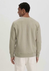 Hellgrüner Sweatshirt mit langen Ärmeln, gerippten Bündchen und Saum; weiche Textur; schlichtes Design ohne sichtbare Muster oder Hardware-Details.