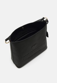 Črna usnjena torba za ramo z odtisnjenim logotipom "LOVE MOSCHINO", zgornje zapiranje na zadrgo in nastavljiv trak. Gladka tekstura z minimalističnim dizajnom.