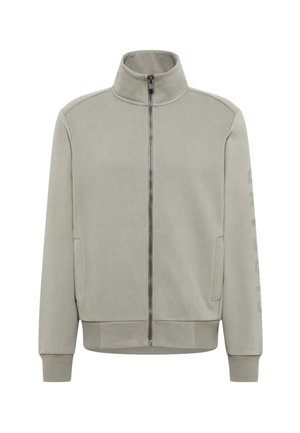Light gray zip-up jacket with a high collar and long sleeves, featuring side pockets and a vertical printed text detail on the sleeve.