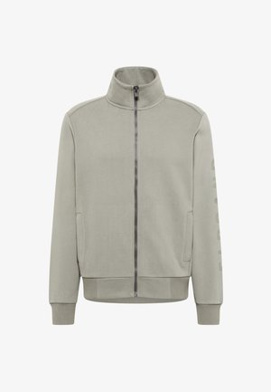 Hellgraue Jacke mit Reißverschluss, hohem Kragen und langen Ärmeln, mit seitlichen Taschen und einem vertikalen Schriftzug auf dem Ärmel.