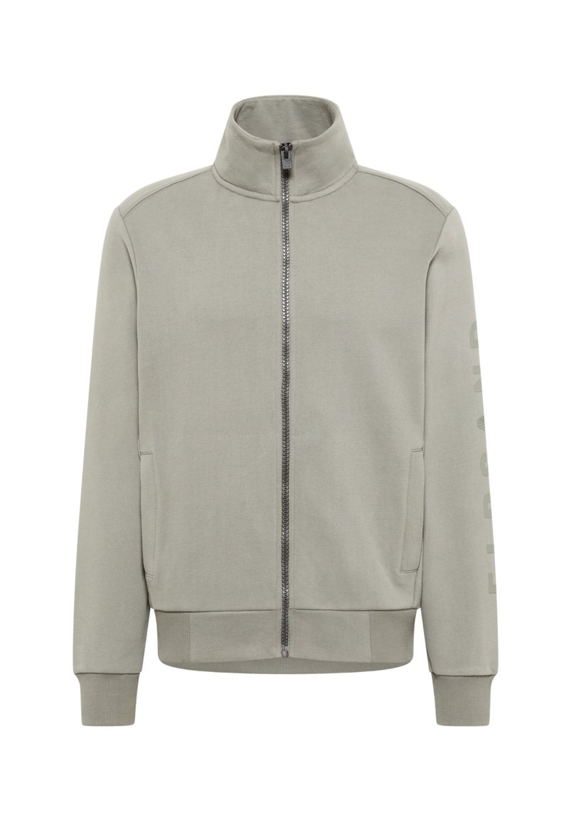 Hellgraue Jacke mit Reißverschluss, hohem Kragen und langen Ärmeln, mit seitlichen Taschen und einem vertikalen Schriftzug auf dem Ärmel.