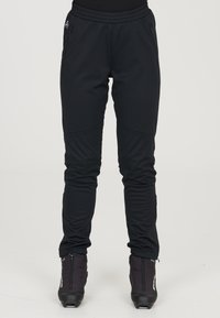 Mustat urheiluhousut, jotka on valmistettu venyväst�ä synteettisestä materiaalista. Niissä on tiukka muotoilu, vetoketjulliset taskut ja kapeat lahkeet, jotka takaavat mukavan istuvuuden.