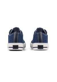 Blue denim sneakers with a textured fabric, white rubber sole, contrasting navy accents, and a logo patch on the heel.