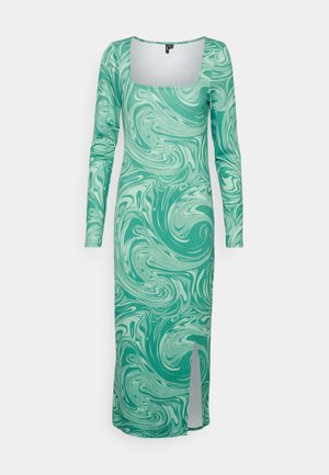 Vestido de mangas compridas com um padrão em espiral verde e menta clara, apresentando um decote quadrado e uma fenda lateral para facilitar o movimento.