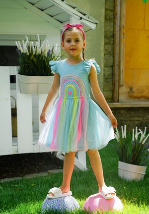 Hellblaues Kleid mit einem bunten Regenbogendesign und einem Tüllrock; verfügt über kurze, gerüschte Ärmel und rosa Akzente. Steht auf dekorativen Kugeln.