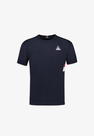 T-shirt in cotone blu navy con maniche corte, collo tondo e un piccolo logo sulla parte superiore sinistra del petto. Presenta dettagli a blocchi di colore sui lati.