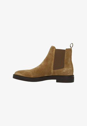 Brown suede Chelsea boot with elastic side panels, rounded toe, and a pull tab at the back. Flat rubber sole with a textured surface.