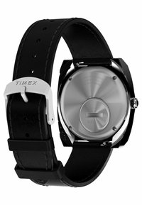 Orologio Timex con cinturino in pelle nera, fibbia in metallo argentato e cassa rotonda in acciaio inox. Finitura liscia sul retro con incisioni.