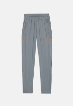 Grå sportbyxor med elastisk midja, sidofickor och röda detaljer. Har en liten Nike-logotyp på vänster lår.