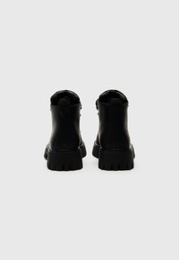 Mustad nahast mustad ankle-boots sileda tekstuuriga, millel on paks käimisosa ja küljes lukuga sulgemine.
