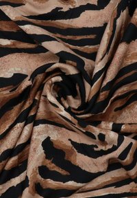 Tessuto animalier con un motivo vorticoso di strisce marroni e nere su uno sfondo beige, con una consistenza liscia e morbida.