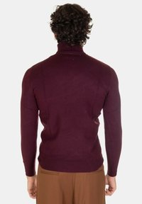 Maglione girocollo bordeaux realizzato in tessuto morbido a maglia, design aderente con maniche lunghe, polsini e orlo a coste.