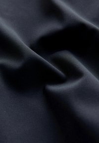 Navy blue fabric with a smooth texture, featuring subtle ripples and folds that show its soft, stretchy quality, suitable for various uses.
