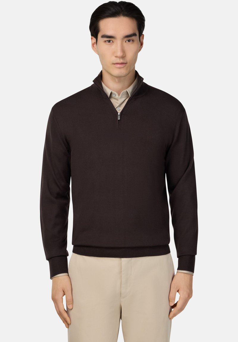 Brown zip-up sweater with long sleeves and ribbed cuffs, worn over a beige collared shirt. Smooth texture, casual fit, minimalistic design.