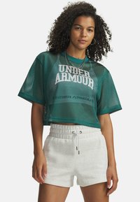 Zelena mrežasta kratka majica z belim logotipom "UNDER ARMOUR". Kombinirajte jo z lahkimi svetlo sivimi kratkimi hlačami z vrvico za zategovanje. Obe kosu imata sproščen kroj.