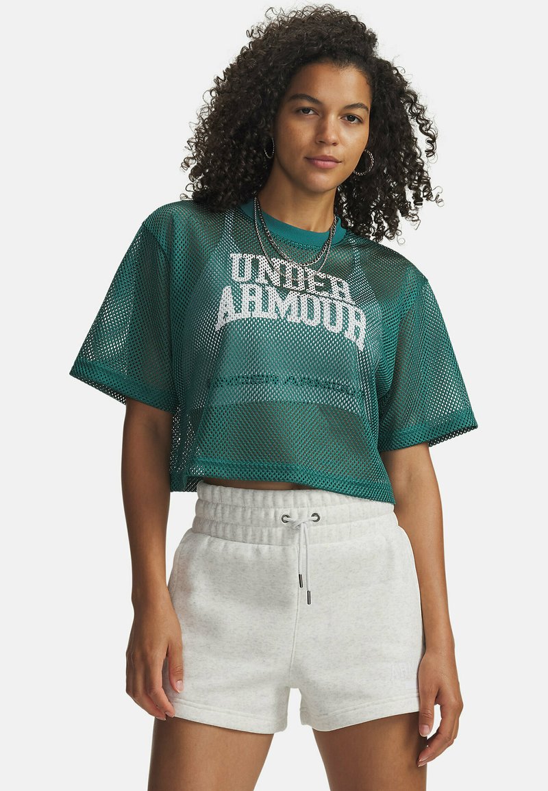 Zelena mrežasta kratka majica z belim logotipom "UNDER ARMOUR". Kombinirajte jo z lahkimi svetlo sivimi kratkimi hlačami z vrvico za zategovanje. Obe kosu imata sproščen kroj.